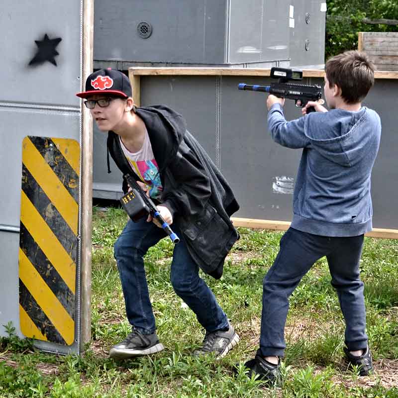 Two kids playing on the laser tag field
